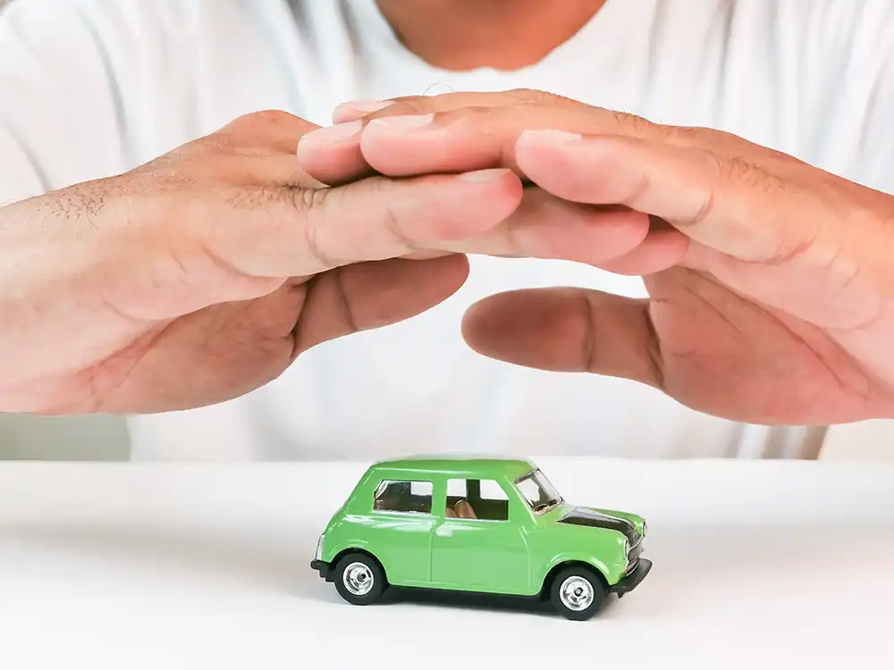 Hands protecting toy car